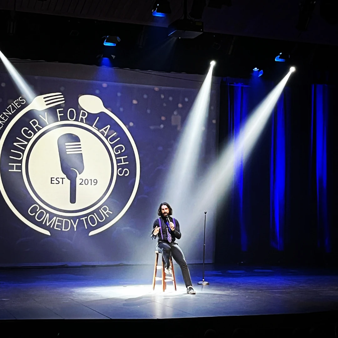 A comedian performing under spotlights