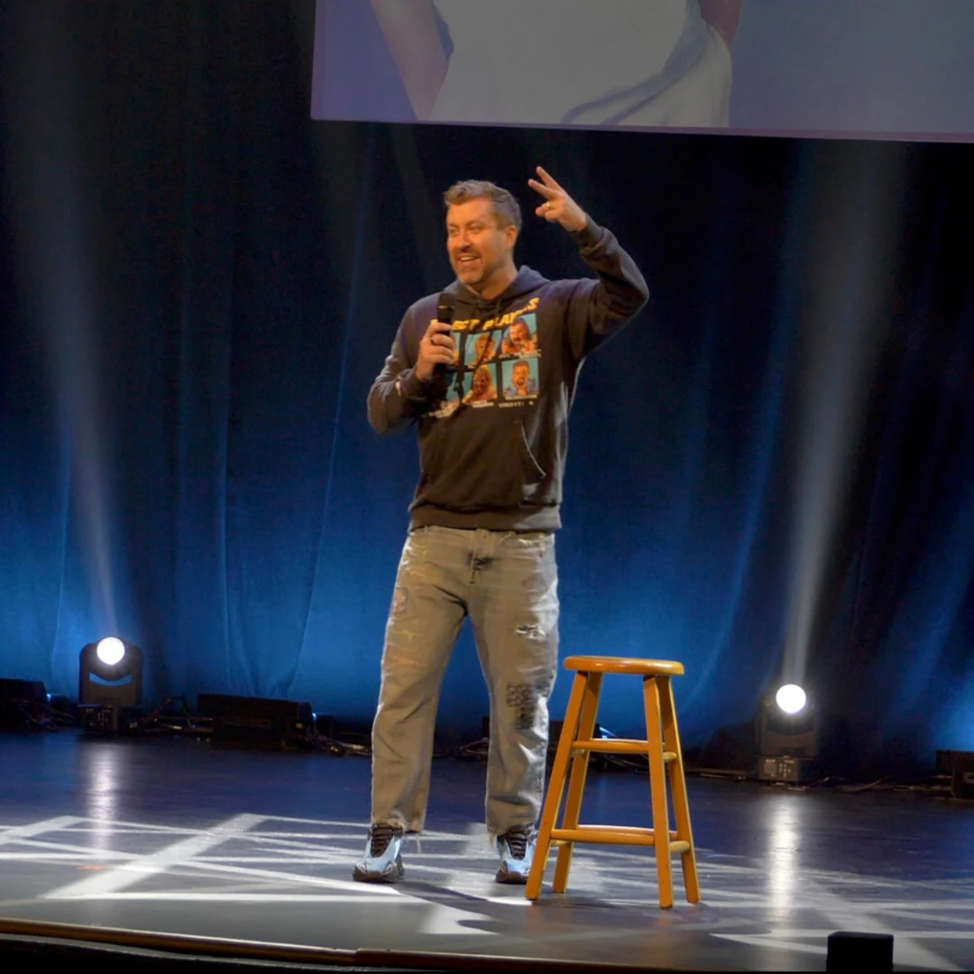 A comedian greeting the audience from the stage